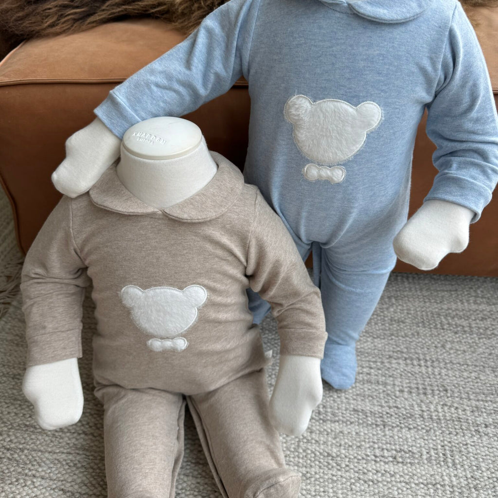 Een paspop met een beige boxpakje met witte beer en een paspop met een blauw boxpakje met witte beer
