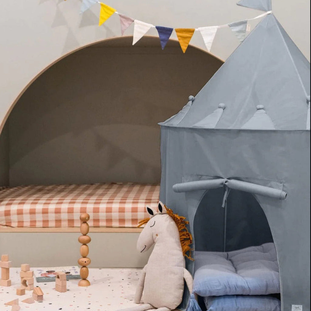 Een blauwe speeltent in de vorm van een kasteel in een kinderkamer