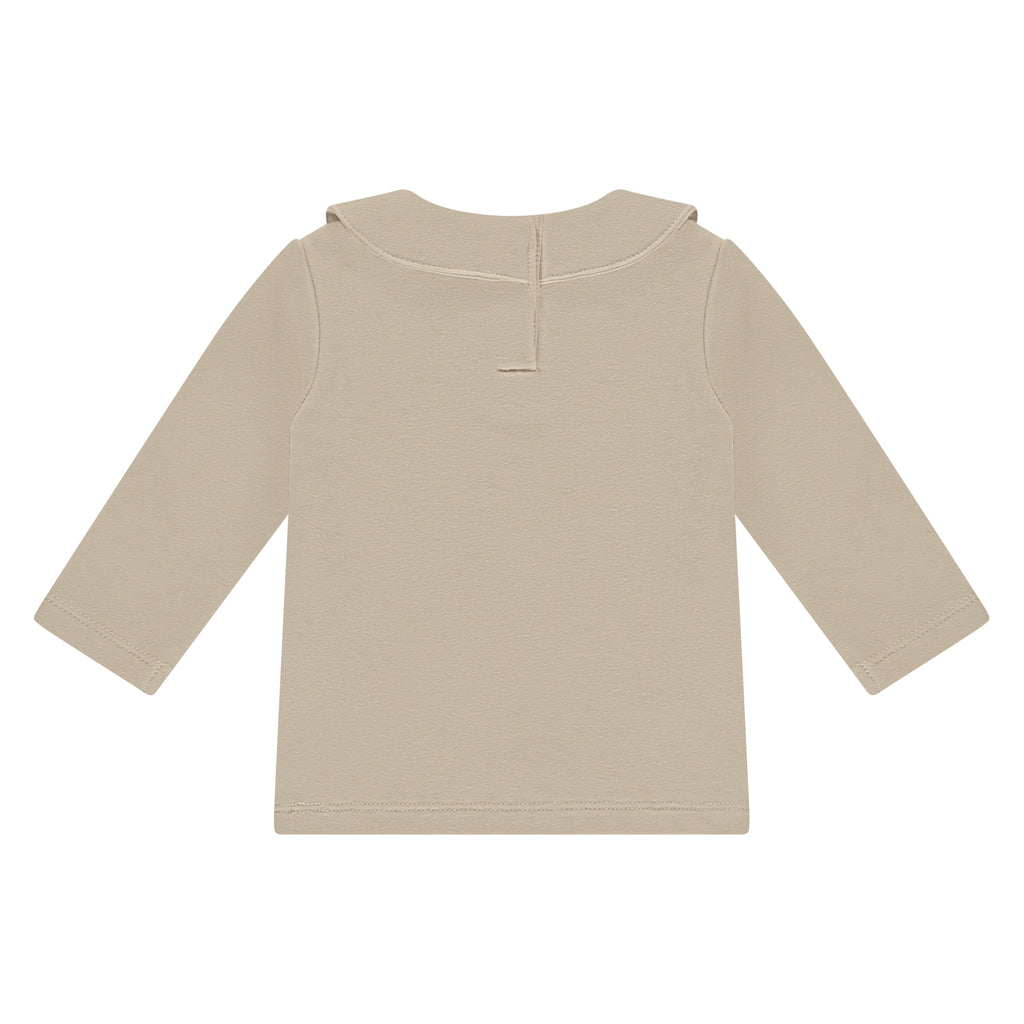 A Tiny Story Long sleeve Beige met een mooie sierlijke kraag en een donker beige klavertje voor op. In maat 44,50,56,62,68,74