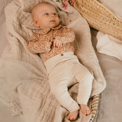 A Tiny Story Romper Newborn in beige bloemenprint. In maat 44,50,56,62,68,74.