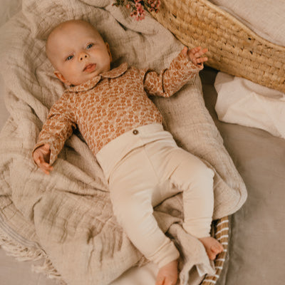 A Tiny Story Romper Newborn in beige bloemenprint. In maat 44,50,56,62,68,74.
