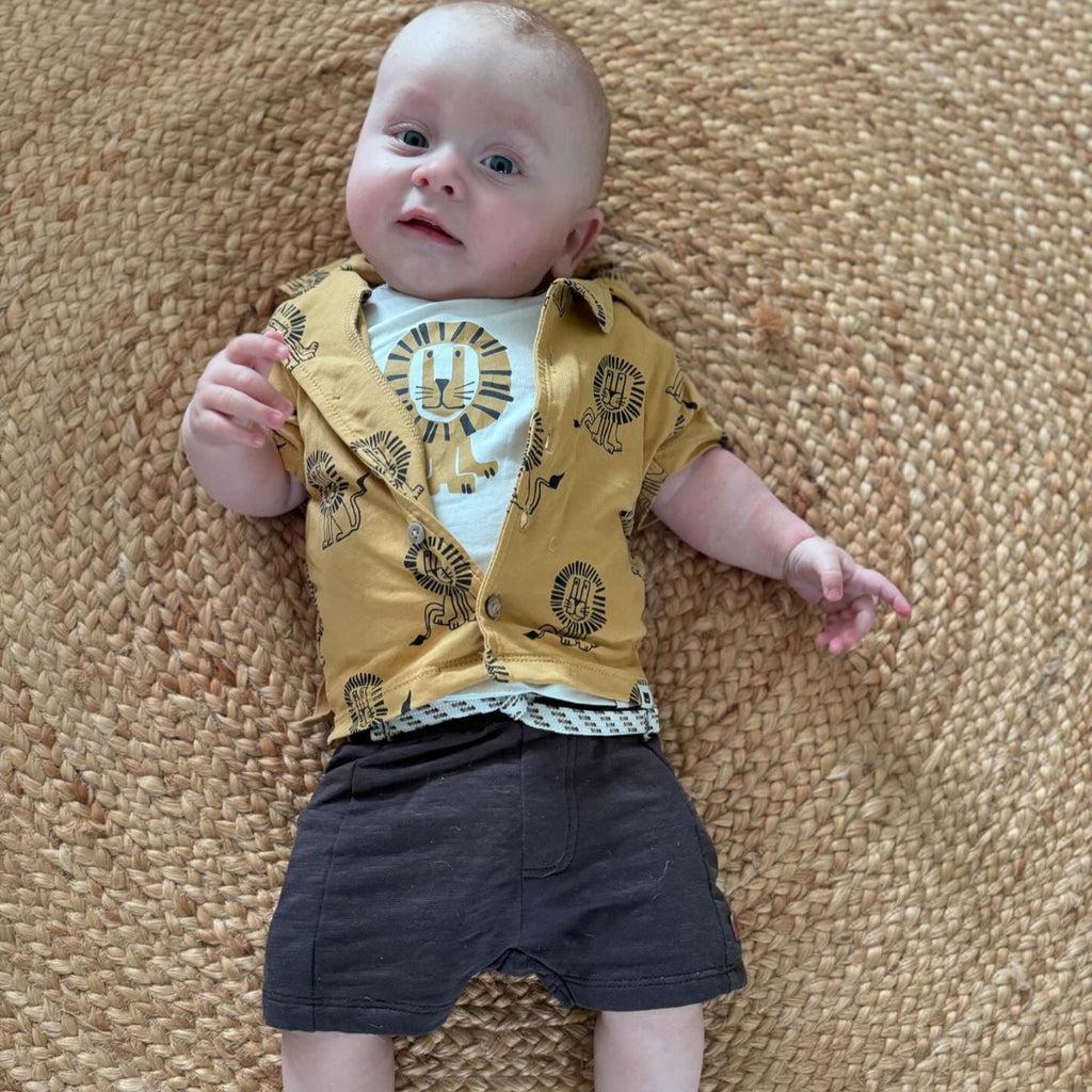 Een babytje in een kort grijs broekje