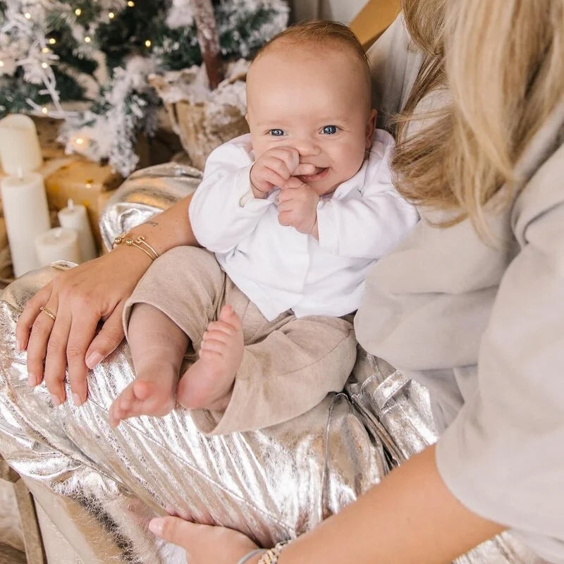 Een babytje in een beige babypakje