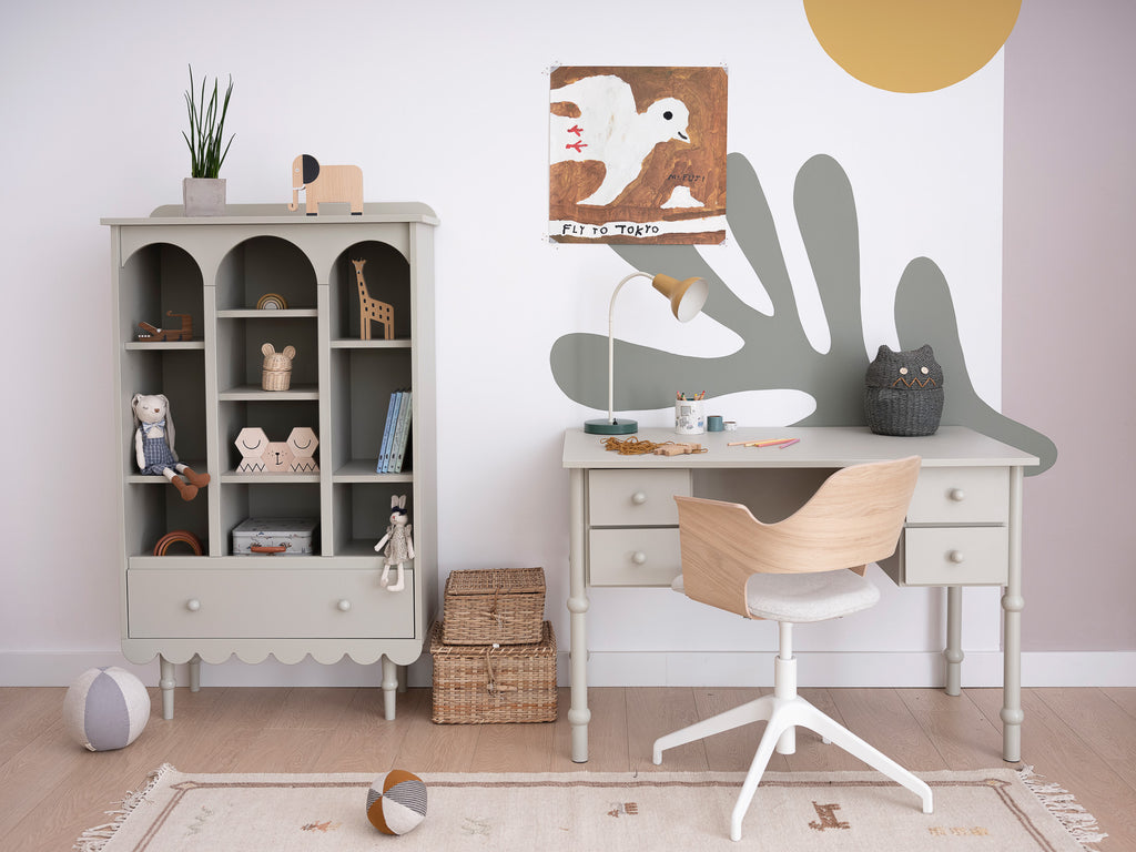 Een kinderkamer met een groene boekenkast en een groen bureau