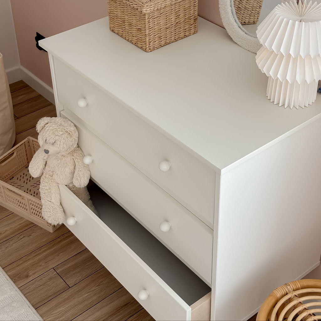 Een witte commode ladekast in een babykamer