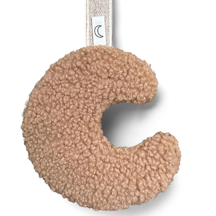 Een beige speenknuffeltje in de vorm van een maantje
