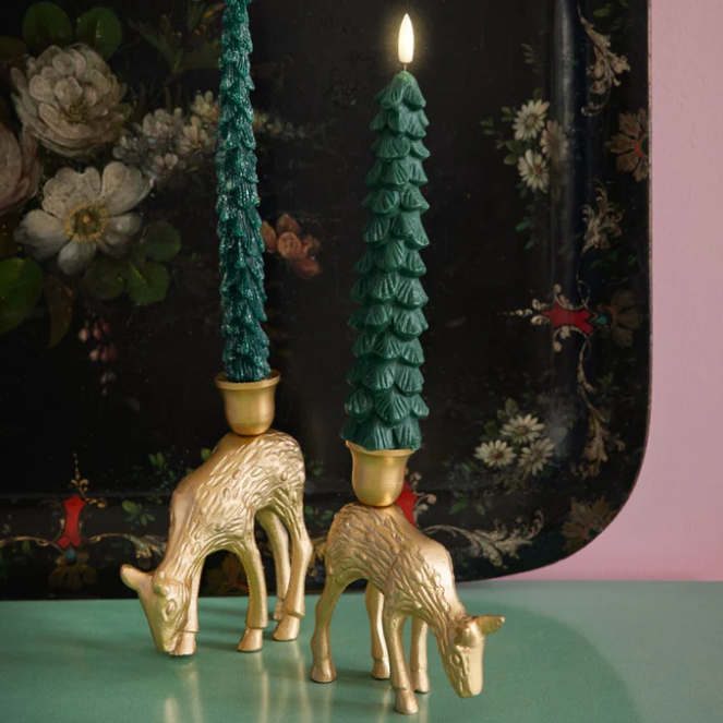 Een kandelaar van gietijzer in de kleur goud in de vorm van een hert.