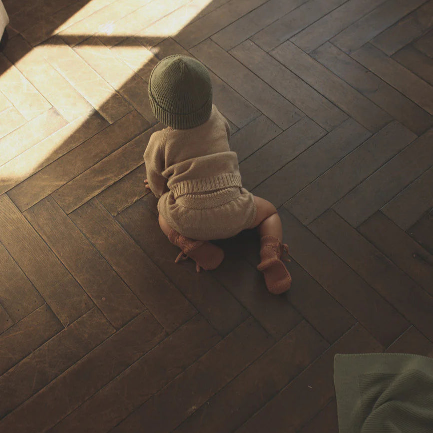 Een baby kruipend in een baby bloomer 