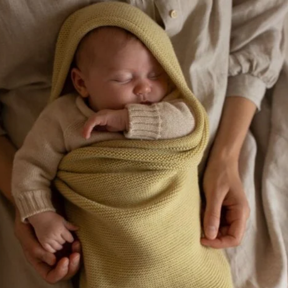 Een licht gele cocoon deken van 100% merinowol voor newborn.