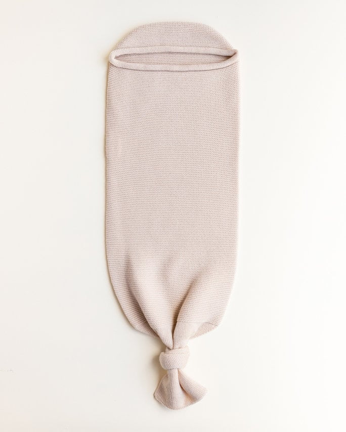 Een licht beige cocoon baby deken