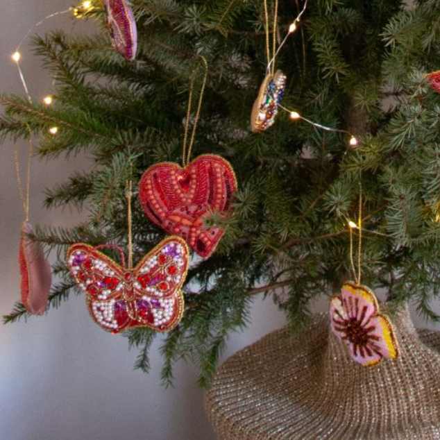 Deze handgemaakte hanger in de vorm van een vlinder versierd met glinsterende kraaltjes en pailletten. 