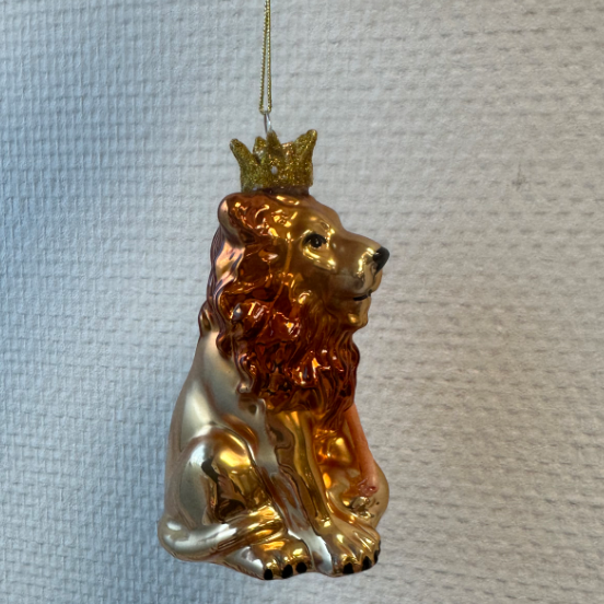 Een kerstboomhanger van een leeuw gemaakt van glas met een kroontje en scepter.