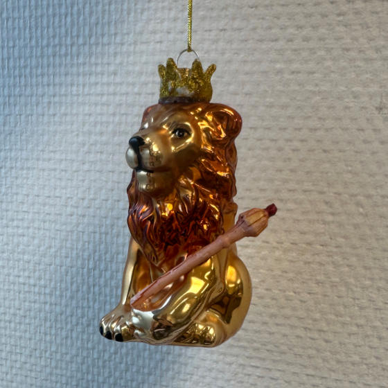 Een kerstboomhanger van een leeuw gemaakt van glas met een kroontje en scepter.