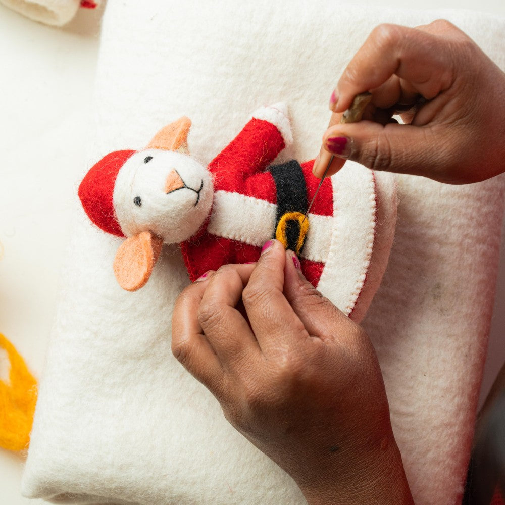 Muis verkleed als kerstman gemaakt van wolvilt.