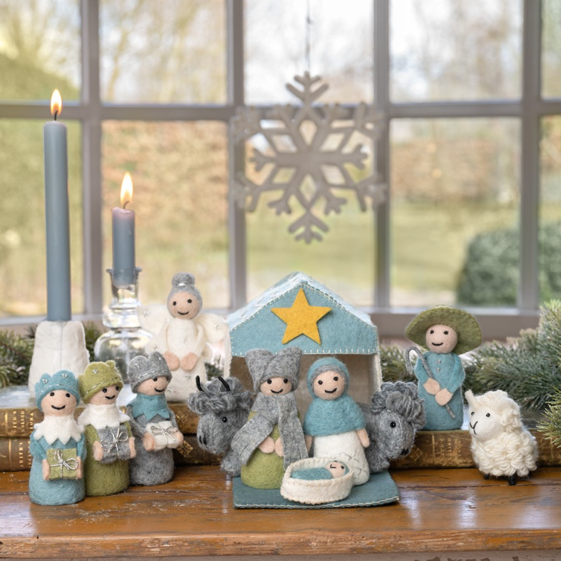Een vilten kerststal in een ijsblauw-witte kleurstelling. Een sfeervolle en unieke set met Maria, Jozef, het kindje Jezus, de drie wijzen, herder, engel en dieren (os, ezel en schaap), inclusief een huisje met ster.