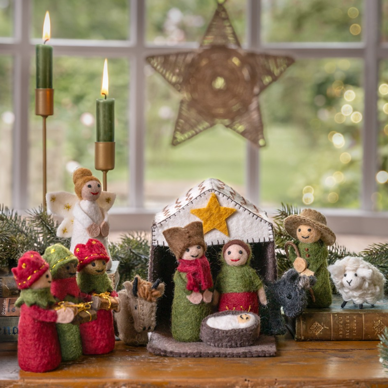 Vilten kerststal in rood-groentinten. Het pakket bevat de volgende 11 kerstfiguren in een stalletje: Jezus, Maria, Jozef, de Drie Koningen, een engel, de herder, een os, een ezel en een schaap. 