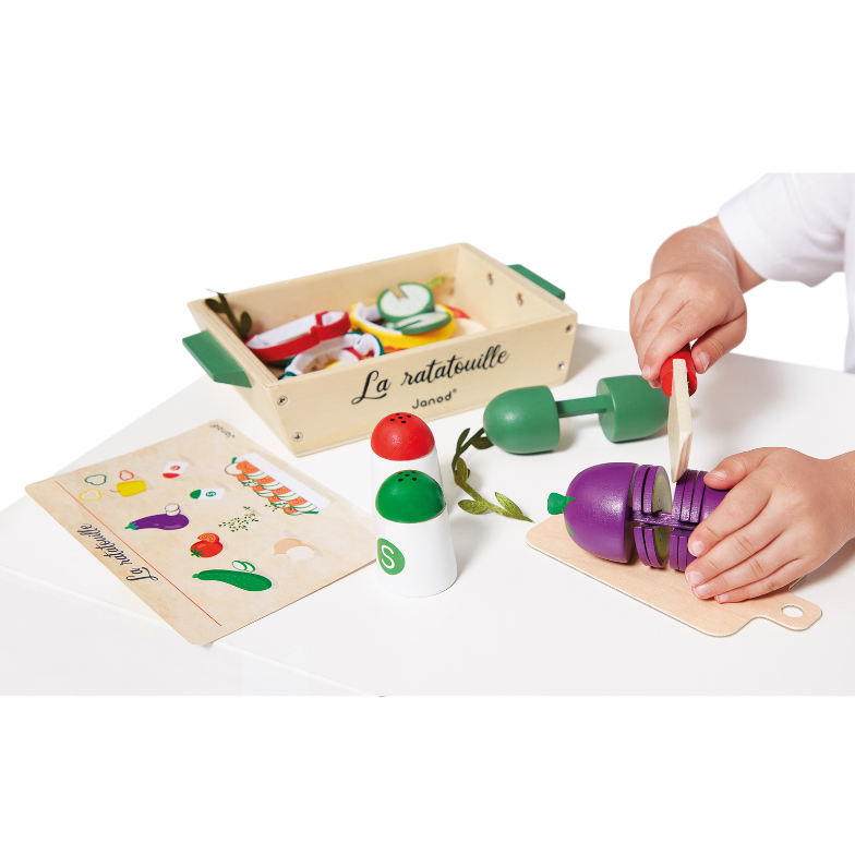 Deze keukenSet met zomergroenten bestaat uit 32 accessoires: een courgette, een aubergine, 4 tomaten, 2 uien, een mes, houten peper-en-zoutstel, alsook 5 vilten plakjes paprika, 3 stoffen kruidentakjes, een receptenfiche en een kartonnen snijplank. Dit alles wordt gepresenteerd in een mooie houten bak.