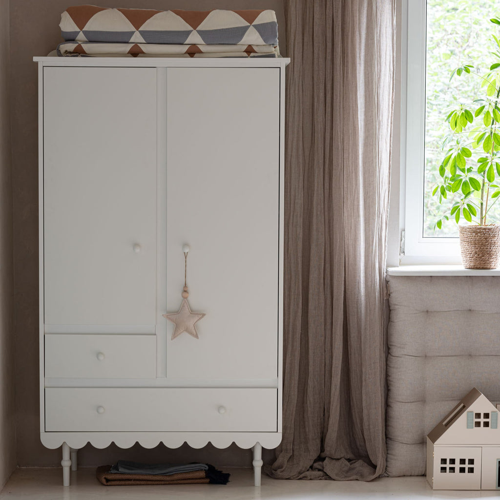 Een witte kledingkast in een kinderkamer