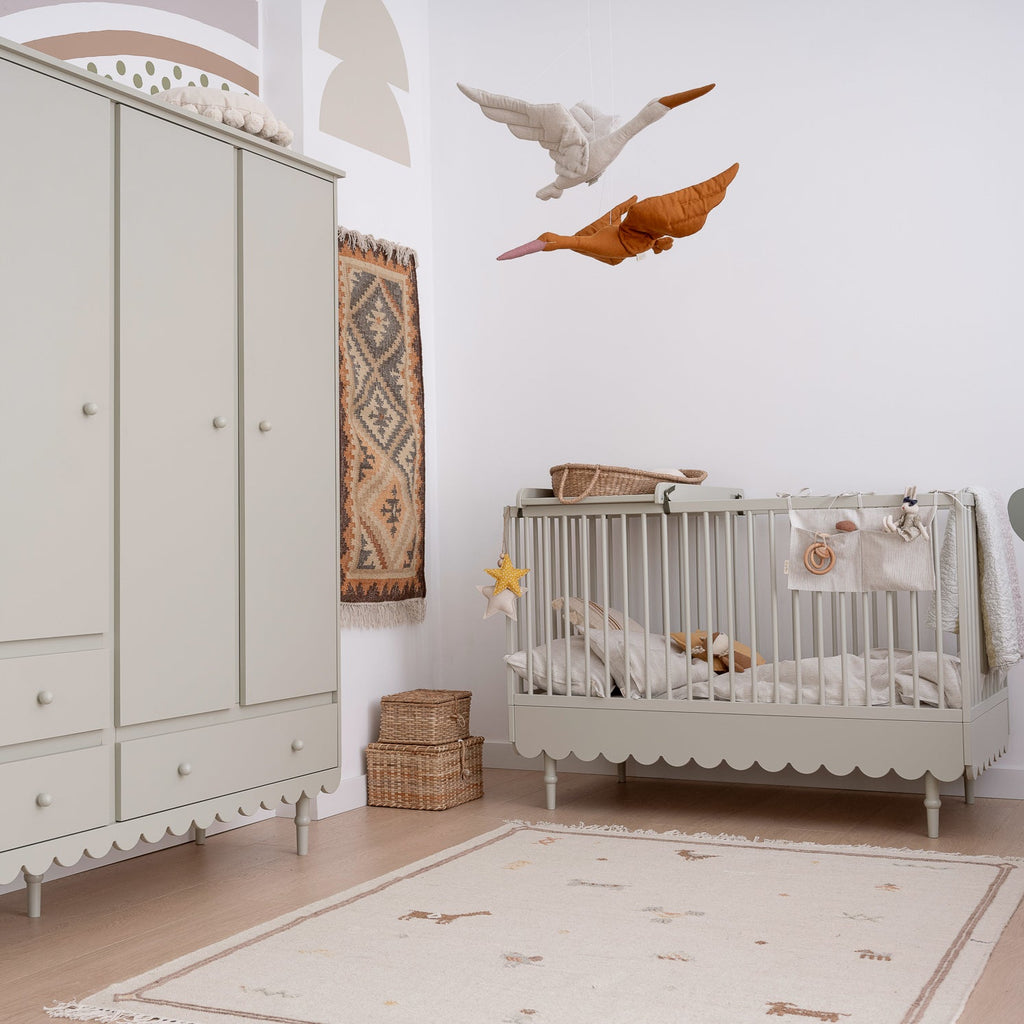 Een kinderkamer met een ledikant en kledingkast in retrostijl