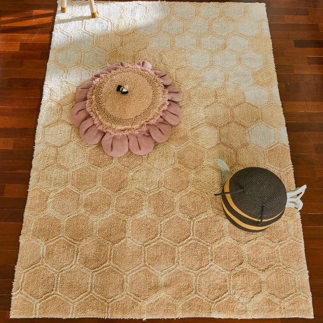 Een rechthoekig katoenen kleed in reliëfs en zachte honingtinten, geïnspireerd op de natuurlijke honingraat die door bijen is gemaakt. Het vloerkleed van Lorena Canals.