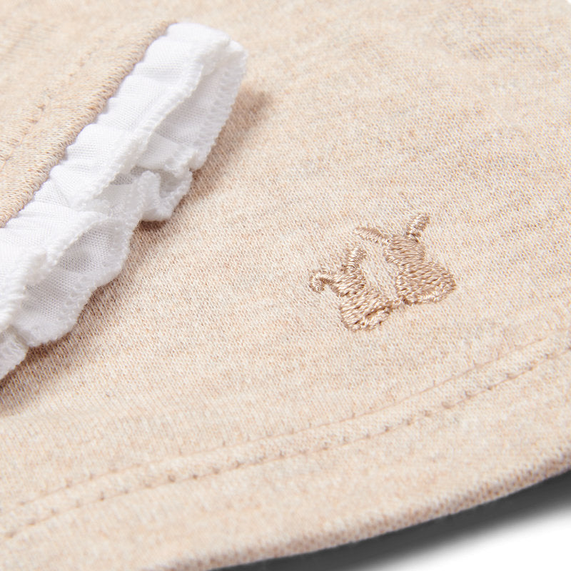 Een beige babypakje met een wit roeseltje