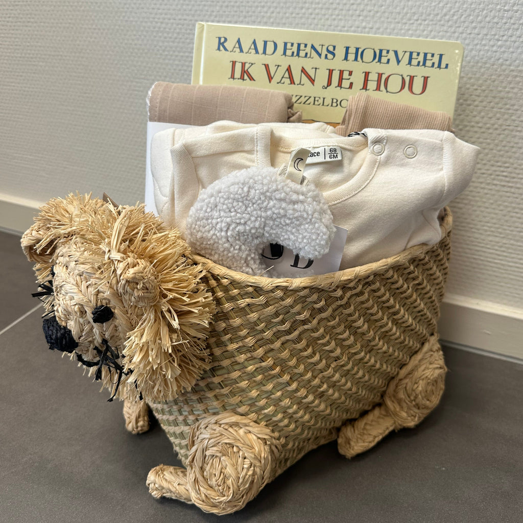 Lovt Amsterdam Kraammand, raffia opbergmand in de vorm van een leeuw met beige kleurige kleding, hydrofiele doek, boek en speenknuffeltje.