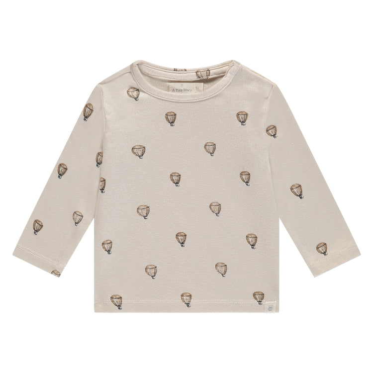 Een gebroken wit babyshirtje met luchtballonnen