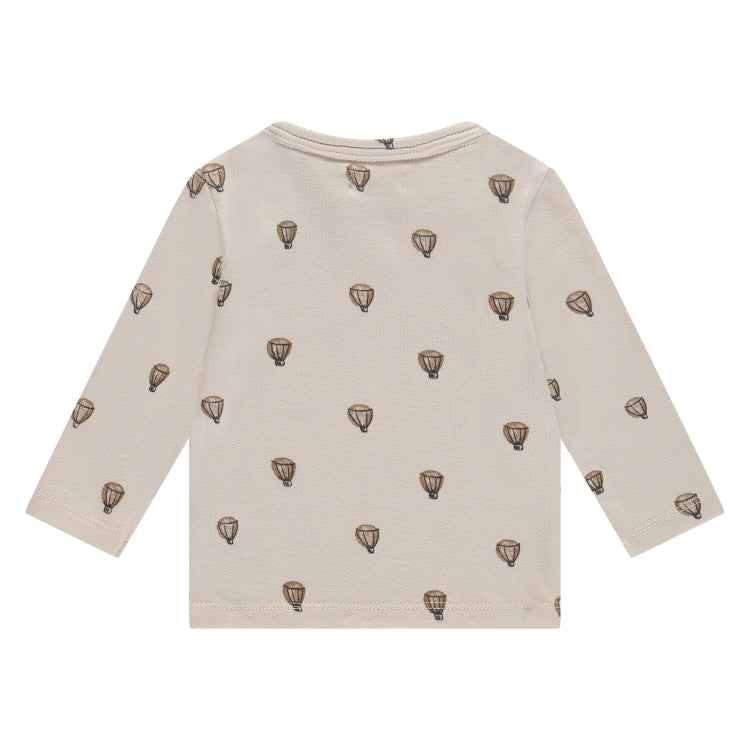 Een gebroken wit babyshirtje met luchtballonnen