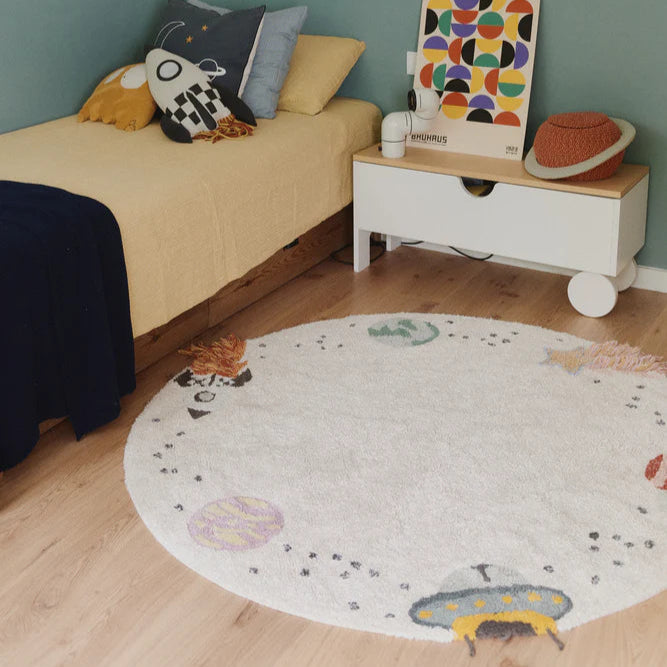 Een rond vloerkleed met astronauten in een kinderkamer
