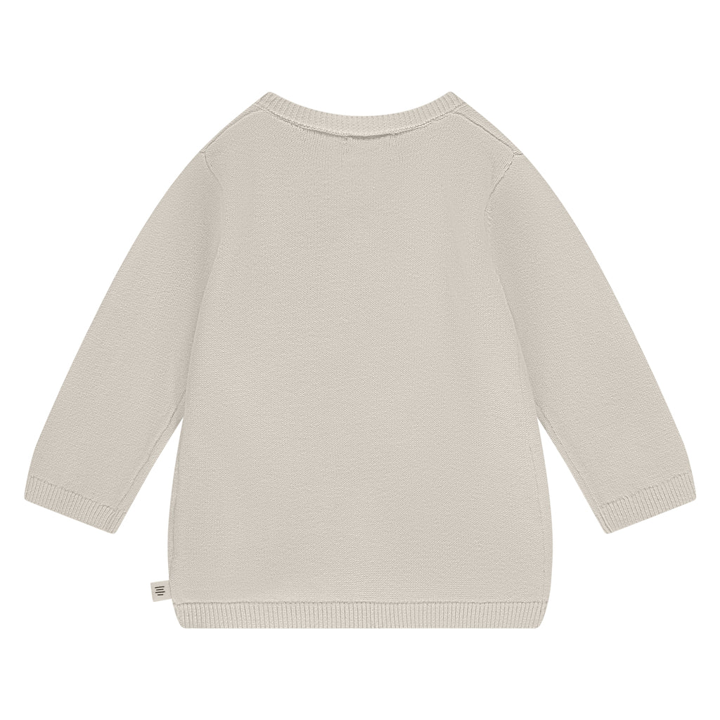 De achterkant van een gebroken wit overslagshirtje.