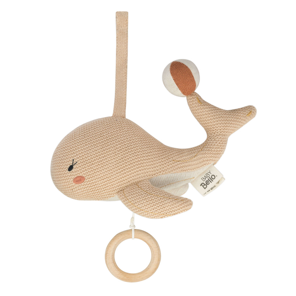 Een beige kleurige muziekmobiel in de vorm van een walvis 