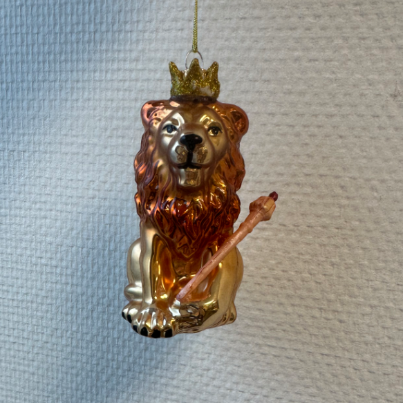 Een kerstboomhanger van een leeuw gemaakt van glas met een kroontje en scepter.