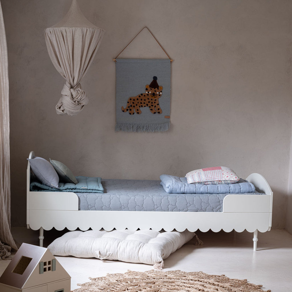 Een wit kinderbed in een kinderkamer