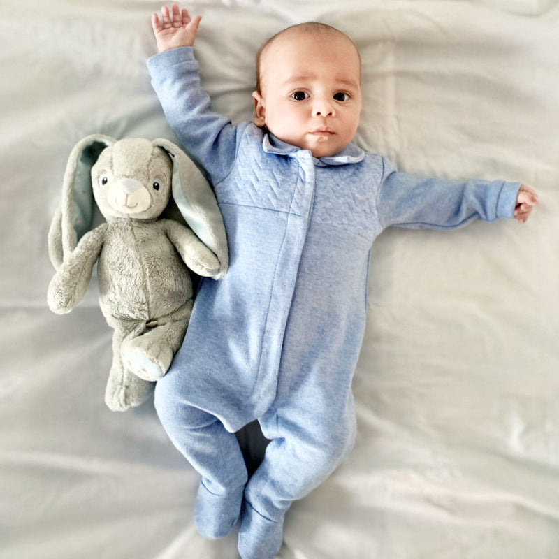 Een baby in een denim blauw babypakje