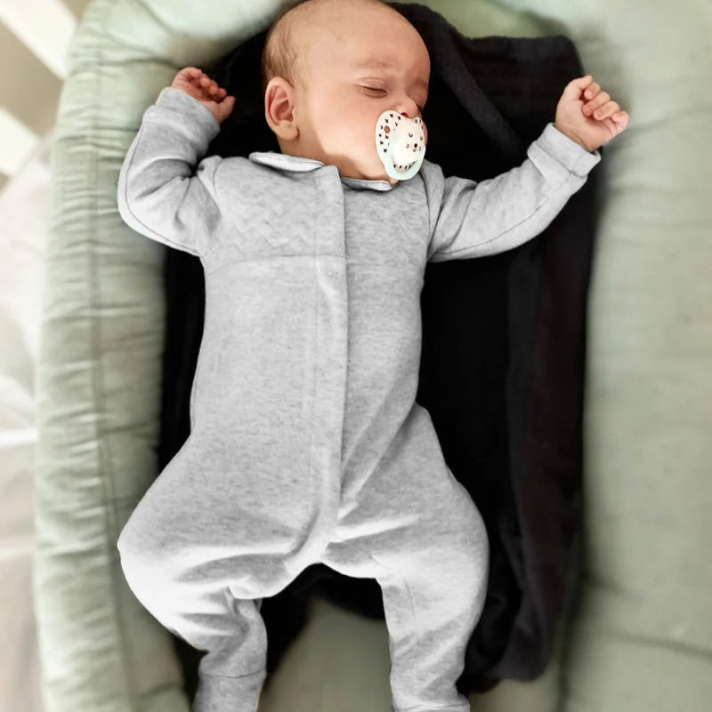 Een baby in een grijs boxpakje