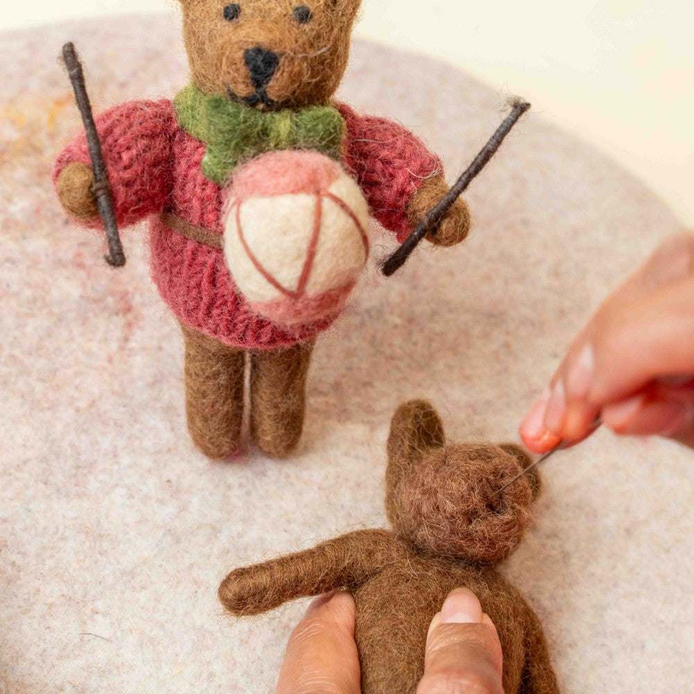 Een kerstboomhanger in de vorm van een beertje met een trommel in zijn hand. In de kleur cyclaam, groen en wit.