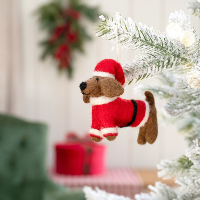 Teckel als kerstman van vilt, met rood pak en kerstmuts. 