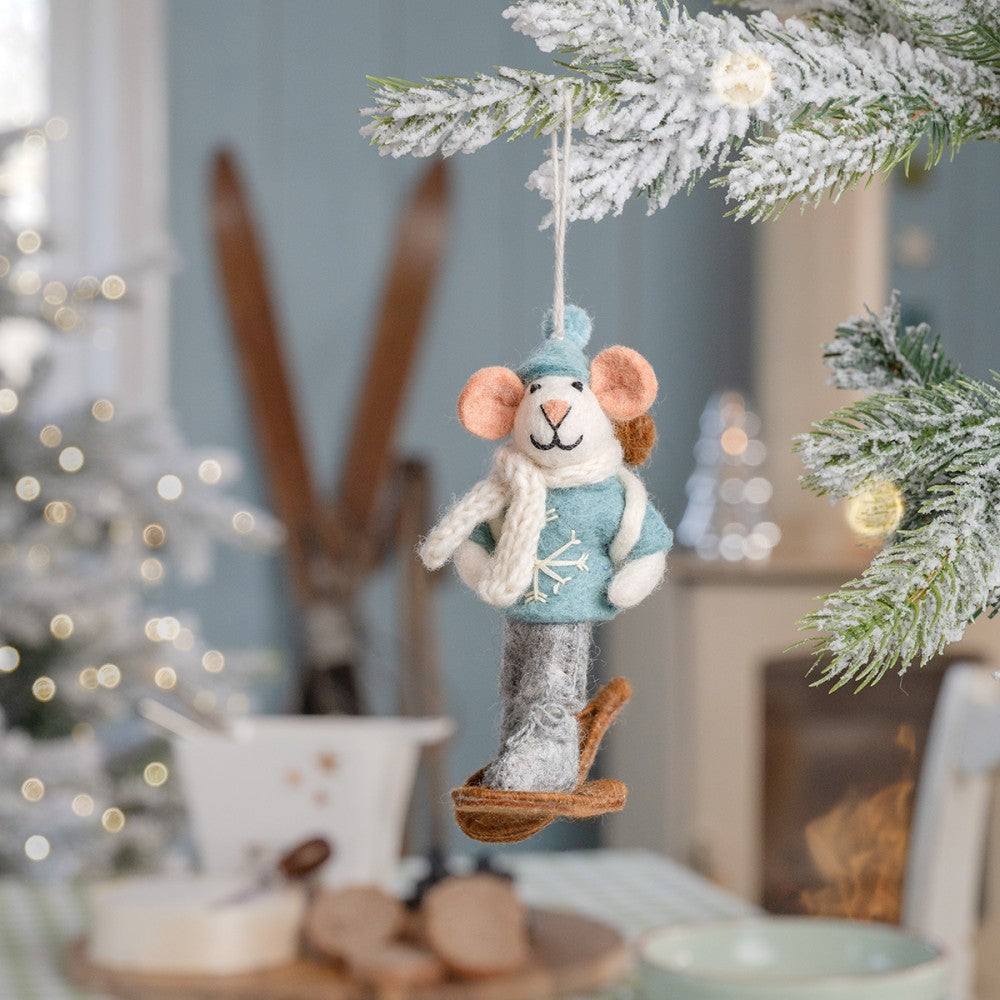 Een kerstboomhanger in de vorm van een muis als sneeuwwandelaar.