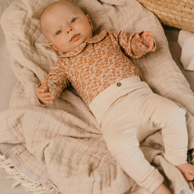 A Tiny Story Romper Newborn in beige bloemenprint. In maat 44,50,56,62,68,74.
