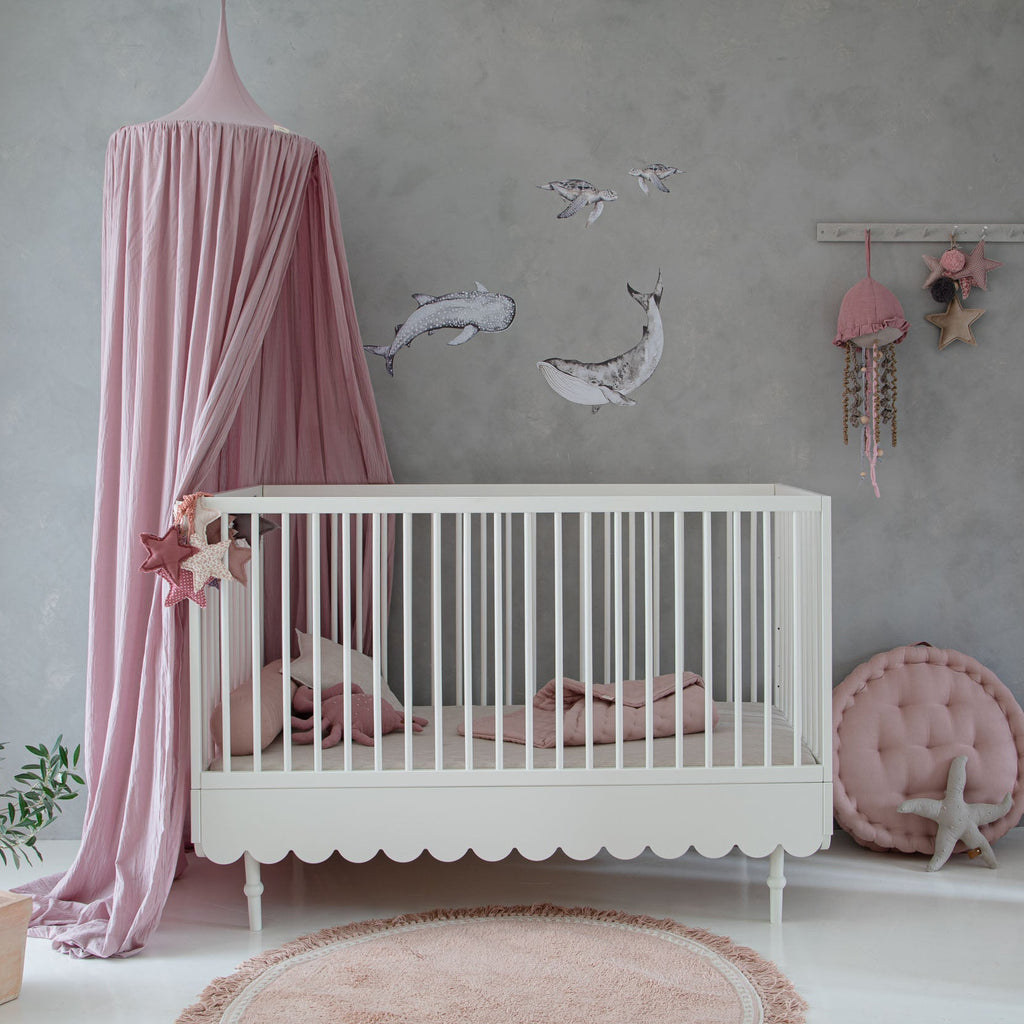 Een wit ledikant in een babykamer