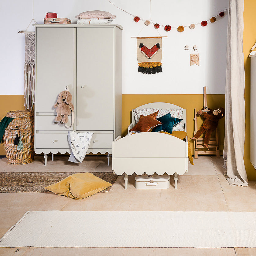 Een olijfgroene kledingkast in retrostijl in een kinderkamer