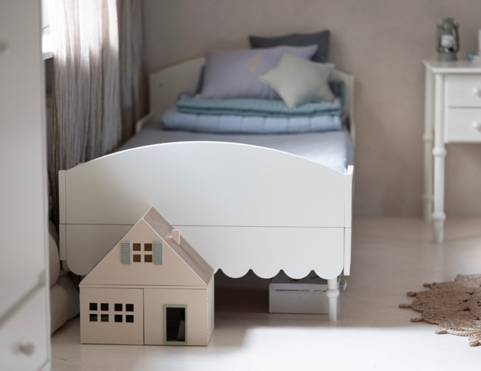 Een wit peuterbed in een kinderkamer