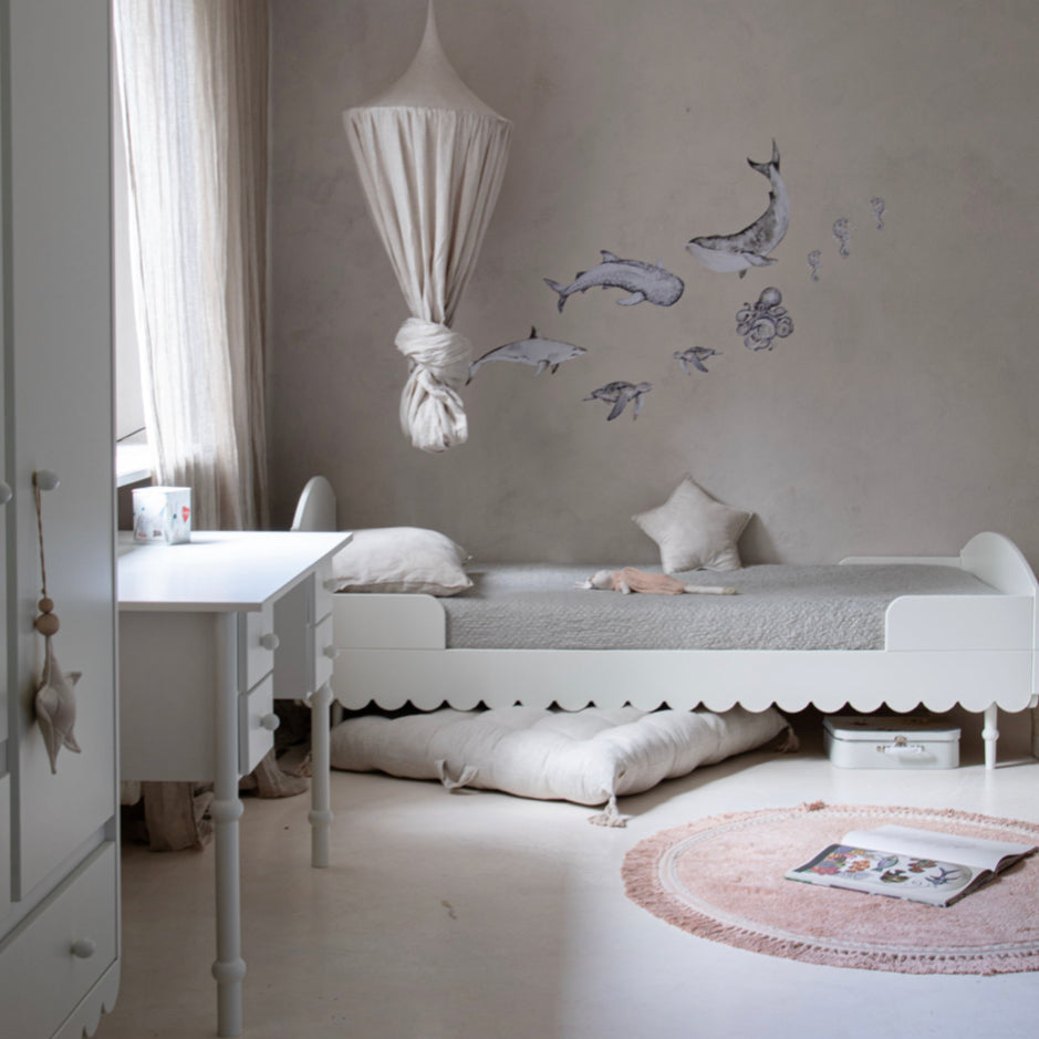 Een wit peuterbed in een kinderkamer